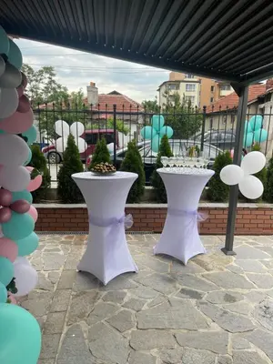 a patio with two white tables and trees at Hotel Consul in Sofia