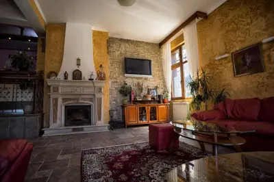 a living room with a couch and a fireplace at Kap House Family Hotel in Bansko