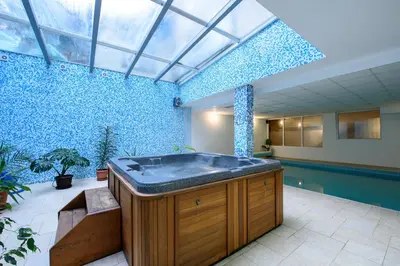 a large bathroom with a tub in the middle of a room at Kap House Family Hotel in Bansko