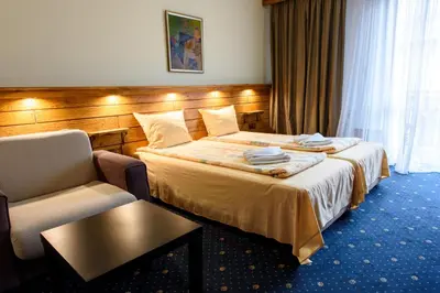 a hotel room with a bed and a chair at Kap House Family Hotel in Bansko