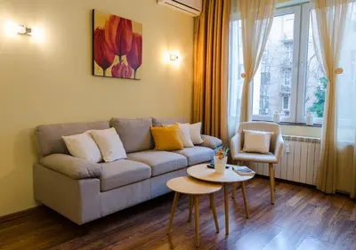 a living room with a couch and a table and a chair at VIP Apartments Sofia in Sofia