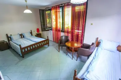 a bedroom with a bed and a table and chairs at Guest House Planinska Sreshta in Balkanets
