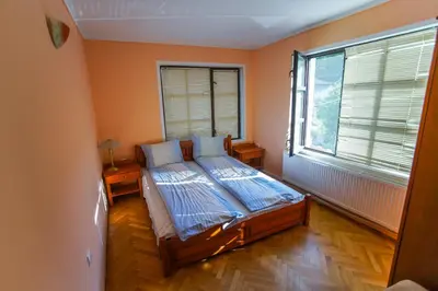 a bedroom with a bed and a large window at Guest House Planinska Sreshta in Balkanets