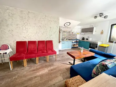 a living room with red chairs and a table at Kassandrova Guest House & Spa in Bratsigovo