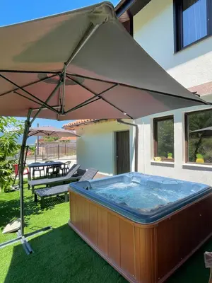 a large tan umbrella sitting on the grass at Kassandrova Guest House & Spa in Bratsigovo
