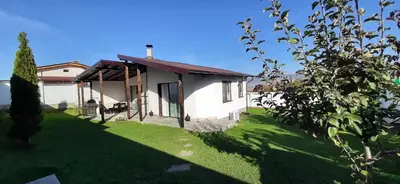 a small white house with a green yard at Villa Gardenia in Sapareva Banya