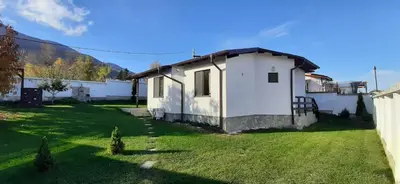 a small white house with a grass yard at Villa Gardenia in Sapareva Banya