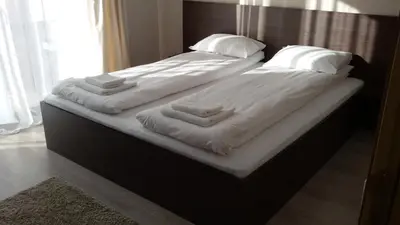 two beds with white sheets and pillows on them at Villa Gardenia in Sapareva Banya