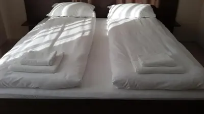 two beds with white sheets and towels on them at Villa Gardenia in Sapareva Banya
