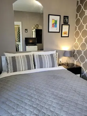 a bedroom with a large white bed and a mirror at Studio M in Plovdiv