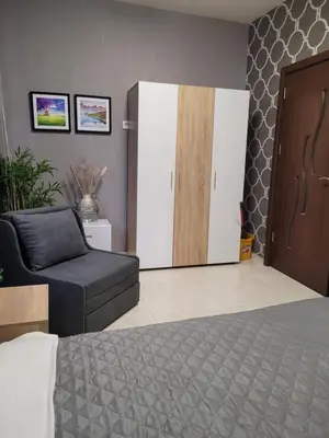 a bedroom with a bed and a chair and a door at Studio M in Plovdiv