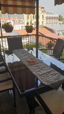 a table and chairs on a balcony with an umbrella at Roman Stadium Apartments in Plovdiv