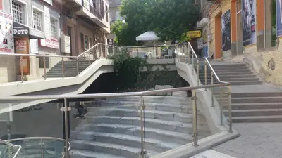 a set of stairs in a city with a person walking down them at Roman Stadium Apartments in Plovdiv