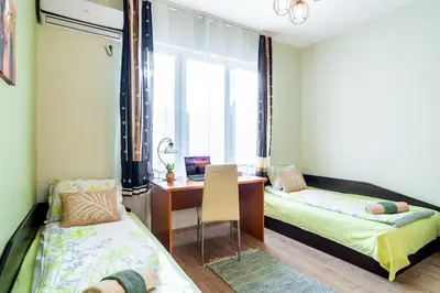 a room with two beds and a desk and a window at Madrid 90 Sq M 2BDR w Parking Spot near Metro, Serdika Mall in Sofia
