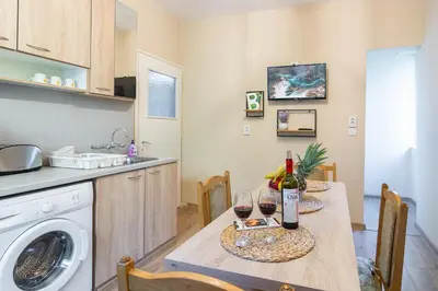 a kitchen with a table with two glasses of wine at Madrid 90 Sq M 2BDR w Parking Spot near Metro, Serdika Mall in Sofia