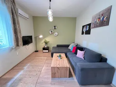 a living room with a blue couch and a wooden coffee table at Madrid 90 Sq M 2BDR w Parking Spot near Metro, Serdika Mall in Sofia