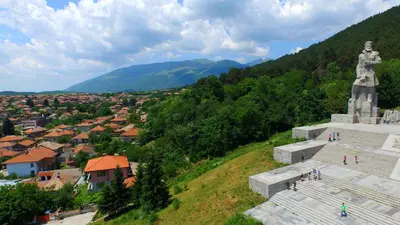 a large statue on top of a hill with a city at Georgievi Guest House in Kalofer