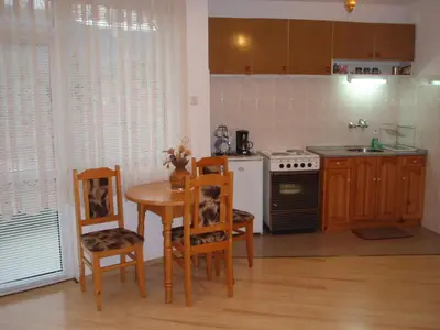 a kitchen with a table and chairs and a stove at Georgievi Guest House in Kalofer