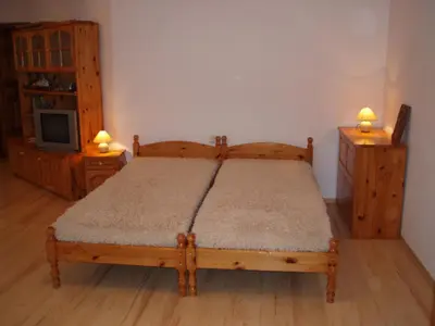 a bedroom with a wooden bed and a tv at Georgievi Guest House in Kalofer