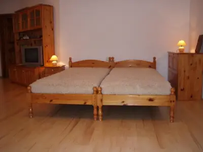 a bedroom with a wooden bed and a tv at Georgievi Guest House in Kalofer