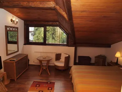 a bedroom with a bed and a chair and a table at Momini Dvori Boutique Guest House in Bansko