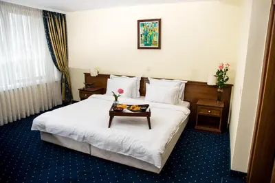 a hotel room with a bed with a tray of food on it at Park Hotel Sankt Peterburg in Plovdiv