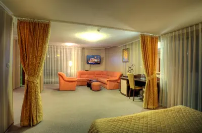 a living room with an orange couch and a desk at Luxor Hotel in Smolyan