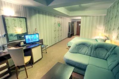 a hotel room with a couch and a bedroom at Luxor Hotel in Smolyan