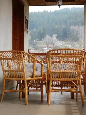 two bamboo chairs sitting on a porch with a view at Family Vacation Home Topolnitza in Koprivshtitsa