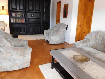 a living room with two chairs and a coffee table at Family Vacation Home Topolnitza in Koprivshtitsa