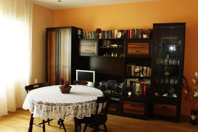 a dining room with a table and a book shelf at Guesthouse Planinsko Gnezdo in Tŭzha