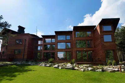 a large wooden house with a green yard at PinusVillas Private Jacuzzi & Phyto-Sauna in Zheleznitsa