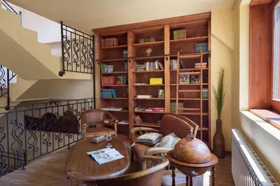 a living room with a table and a book shelf at PinusVillas Private Jacuzzi & Phyto-Sauna in Zheleznitsa