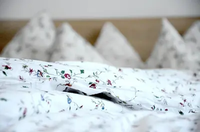 a white sheet with flowers on a bed at Architectural City Loft in Sofia