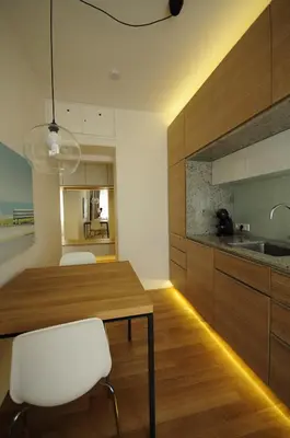 a kitchen with a wooden table and white chairs at Design Apartment in Park in Sofia