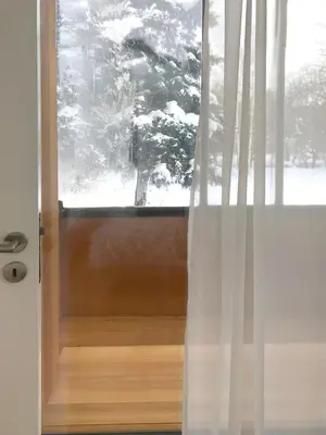 a glass door with a window with snow on it at Design Apartment in Park in Sofia