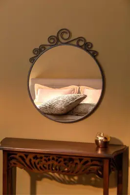 a mirror on a table with a bed and pillows at Silver & Gold Apartment in Sofia