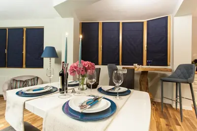 a dining room with a white table with plates and glasses at Silver & Gold Apartment in Sofia