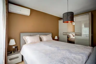 a bedroom with a large bed and a mirror at Silver & Gold Apartment in Sofia