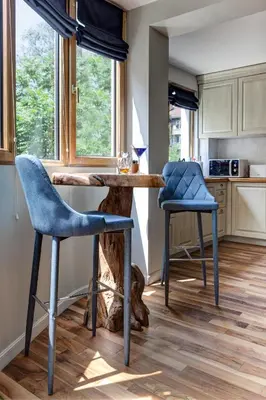 a kitchen with two blue bar stools and a counter at Silver & Gold Apartment in Sofia