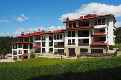 a large building with a red roof on a hill at High Five Villas in Pamporovo