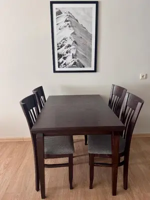 a wooden table with two chairs and a picture on the wall at Bansko Royal Towers Hotel in Bansko
