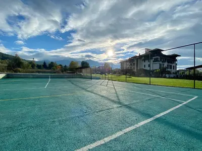 a tennis court in front of a building at Hotel Orbel in Dobrinishte