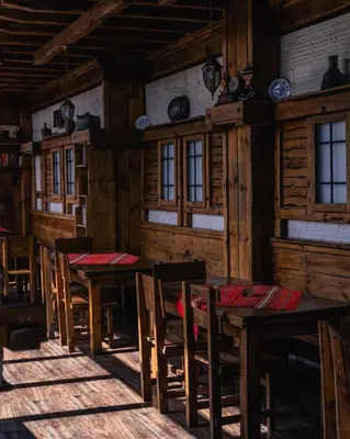 a dining room with tables and chairs in a cabin at Hotel Orbel in Dobrinishte