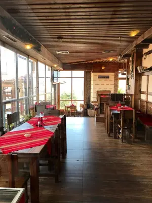 a dining room with wooden tables and red napkins at Hotel Orbel in Dobrinishte