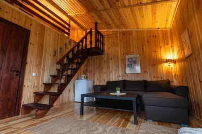 a living room with a couch and a spiral staircase at Hotel Orbel in Dobrinishte