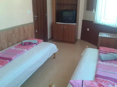 two beds in a room with a tv at Osogovo Rooms in Sofia
