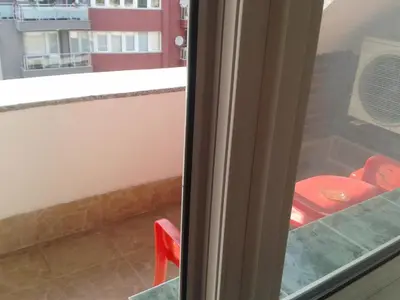 a red chair sitting in front of a window at Osogovo Rooms in Sofia