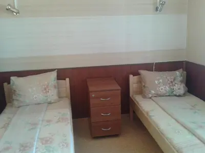 two beds with pillows and a night stand in a room at Osogovo Rooms in Sofia
