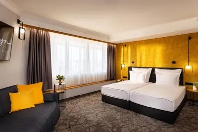 a hotel room with a large bed and a couch at Rosslyn Thracia Hotel Sofia in Sofia